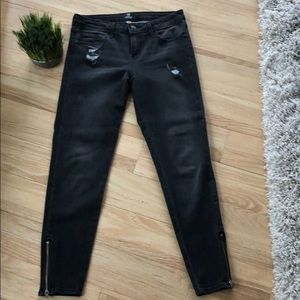 Black ankle jeans with zippers on bottom.